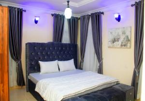 a bed with a blue headboard in a bedroom at House 4 Guest House & Apartments in Lagos