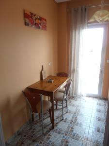 a dining room table with chairs and a window at Apartments Palladium in Olympiaki Akti