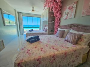 a bedroom with two beds with pink flowers at Mar de Cerejeira in Arraial do Cabo