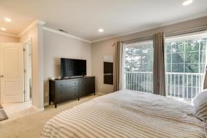 a bedroom with a bed and a tv and a window at Lake Oswego Home with Deck 9 Mi to Downtown Portland in Lake Oswego