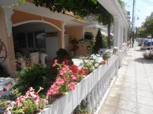 a white fence with flowers on the side of a building at Apartments Palladium in Olympiaki Akti