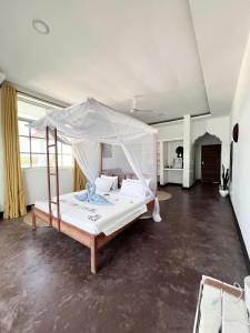 ein Schlafzimmer mit einem Himmelbett in der Unterkunft Crystal Beach Nungwi in Nungwi