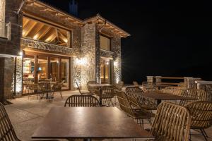 an empty patio with tables and chairs at night at 5 Raches Suites in Arachova