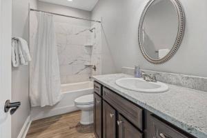 a bathroom with a sink and a toilet and a mirror at Luxury 2 Bedroom townhouse #6 in Lake Charles +10 photos