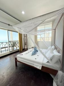 a bedroom with a white bed with a canopy at Crystal Beach Nungwi in Nungwi