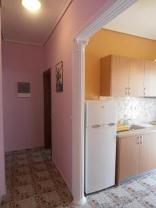 a kitchen with a white refrigerator in a room at Apartments Palladium in Olympiaki Akti