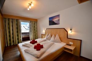 ein Schlafzimmer mit einem Bett mit zwei roten Kreuzen darauf in der Unterkunft Ferienhaus Ban Brösign in Umhausen