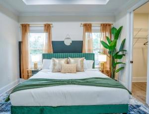 a large bed with a green headboard in a bedroom at Downtown escape: Lakes & Parks - 20min to Airport in Tallahassee