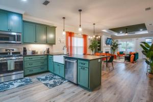 a kitchen with green cabinets and a living room at Downtown escape: Lakes & Parks - 20min to Airport in Tallahassee