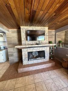 a living room with a stone fireplace with a tv at The valley in Creel