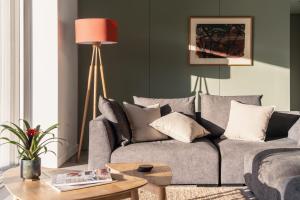Tethera: Eco-Luxury Passivhaus on Ullswater في ووتِرميلوك: غرفة معيشة مع أريكة رمادية وطاولة