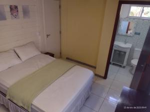 a small bedroom with a bed and a bathroom at APARTAMENTO MARISCAL in Bombinhas