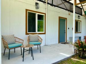 a patio with two chairs and a table and a door at Off-Grid Getaway with Ocean Views in Paradise in Pahoa