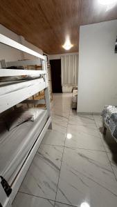 Cette chambre est dotée de carrelage et de 2 lits superposés. dans l'établissement Pousada Alfa, à Abraão