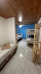 a room with two bunk beds and a wooden ceiling at Pousada Alfa in Abraão