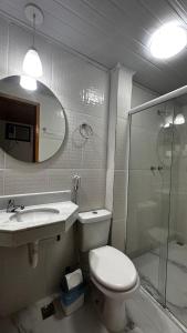 a bathroom with a toilet and a sink and a shower at Pousada Alfa in Abraão