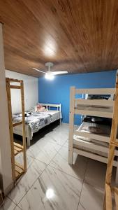 a room with two bunk beds and a blue wall at Pousada Alfa in Abraão