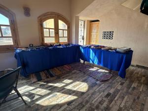 a room with a row of blue tables in a room at ACHERTOD NUBIAN HOTEL in Naj‘ al Maḩaţţah