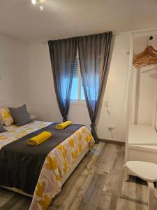 a bedroom with a bed with yellow sheets and a window at Apartamentos La Mar in Altea
