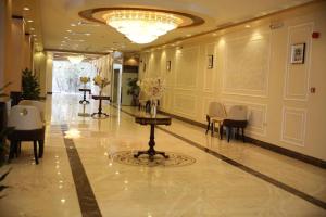 vestíbulo con mesa, sillas y lámpara de araña en فندق هلا اثنين en Arar