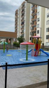 a swimming pool with a playground in a building at Apartamento Girardot Peñalisa con Piscina in Ricaurte
