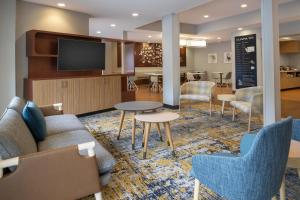 TownePlace Suites by Marriott Olympia في أولمبيا: غرفة معيشة مع أريكة وكراسي وتلفزيون