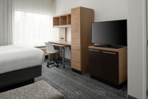 a hotel room with a bed and a desk with a television at TownePlace Suites by Marriott Olympia in Olympia