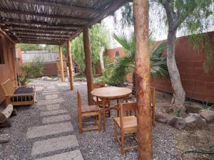 un patio con mesa y sillas bajo una pérgola en Punta Pequena, en San Juanico