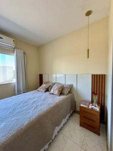 a bedroom with a large bed and a window at Apto Luxo completo 3 quartos em Guriri 300 mts da praia Wi-fi grátis in Guriri