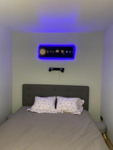 um quarto com uma cama com uma luz azul por cima em Modern Apartment em Narva