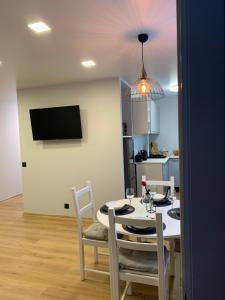 a dining room with a table and chairs and a television at Modern Apartment in Narva