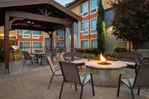 un patio con mesas, sillas y una hoguera en TownePlace Suites by Marriott Olympia, en Olympia