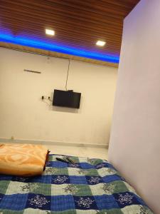 1 dormitorio con 1 cama y TV en la pared en Keshavkunj The Home Stay!!! en Mahabaleshwar