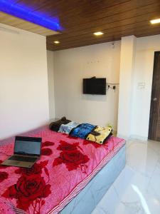 1 dormitorio con 1 cama con ordenador portátil en Keshavkunj The Home Stay!!! en Mahabaleshwar
