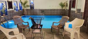 a group of chairs sitting next to a swimming pool at Hotel Ushaan Haveli in Udaipur