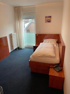 Postel nebo postele na pokoji v ubytování Hotel Merkenich