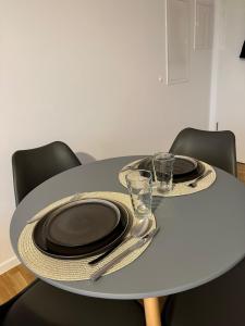 a table with plates and glasses on top of it at Gemütliche Wohnung mit Terrasse in Blumberg