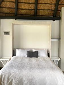 a bedroom with a large white bed with two pillows at LAKE-HOUSE CABIN in Witbank