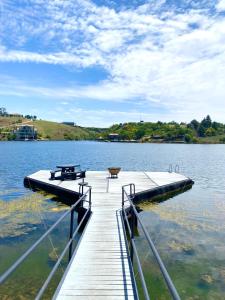 a wooden dock with a picnic table on a lake at LAKE-HOUSE CABIN in Witbank