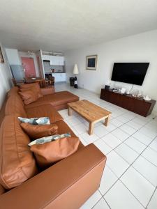 ein Wohnzimmer mit einem Sofa und einem Couchtisch in der Unterkunft Suite Résidence Mont Vernon in Orient Bay French St Martin