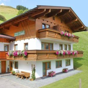 a building with a bench and flowers on it at Appartementhaus Daniel in Saalbach-Hinterglemm