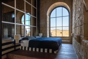 a bedroom with a bed and a large window at Palazzo Petrvs in Orvieto