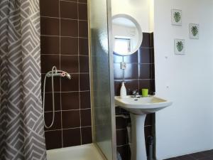 a bathroom with a sink and a shower with a mirror at Malinowy Domek in Karpacz