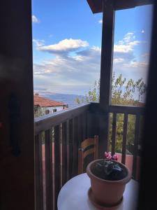een vaas op een tafel op een balkon met een raam bij ΠΑΛΙΟ ΧΩΡΙΟ in Palaios Panteleimon