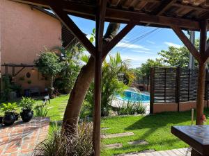a backyard with a palm tree and a swimming pool at Namaste Flats Praia do Rosa in Imbituba