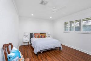 a white bedroom with a bed and a chair at 3 Bedroom House on the Lake in Lake Charles