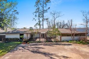 an older house with a driveway and trees at 3 Bedroom House on the Lake in Lake Charles