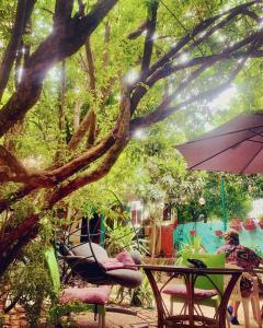 a table and chairs under a tree with an umbrella at hostel vague in Antalya