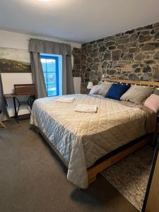 - une chambre avec un grand lit et un mur en pierre dans l'établissement ŠTAJNHAUS DUBICE, 