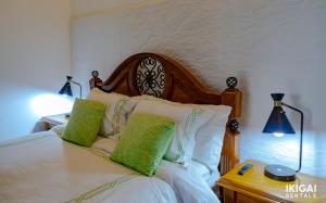 sypialnia z łóżkiem z 2 zielonymi poduszkami w obiekcie Casa Rinu w San José